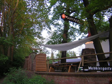 Ausschank-Hütte mit leuchtendem Waldbiergarten-Schild am Abend